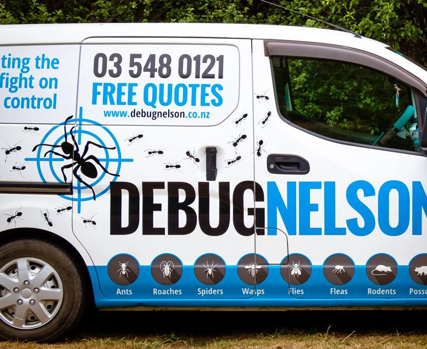 A white Debug Nelson van with the ant-in-crosshair logo, the phone number and a row of pest badges